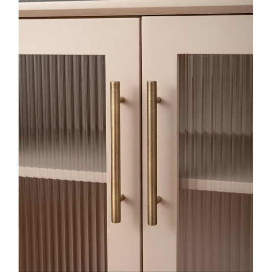 Messing kastgrepen op crèmekleurige kast met geribbeld glas, modern interieur