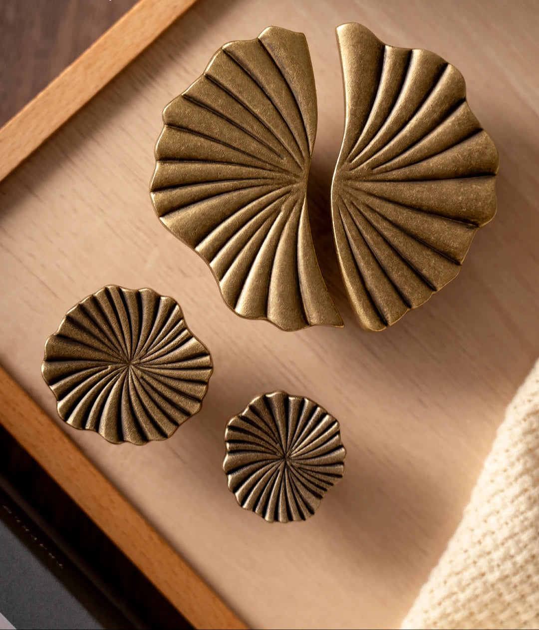 Messing gekleurde luxe knoppen en grepen met schelpvormig design op houten ondergrond