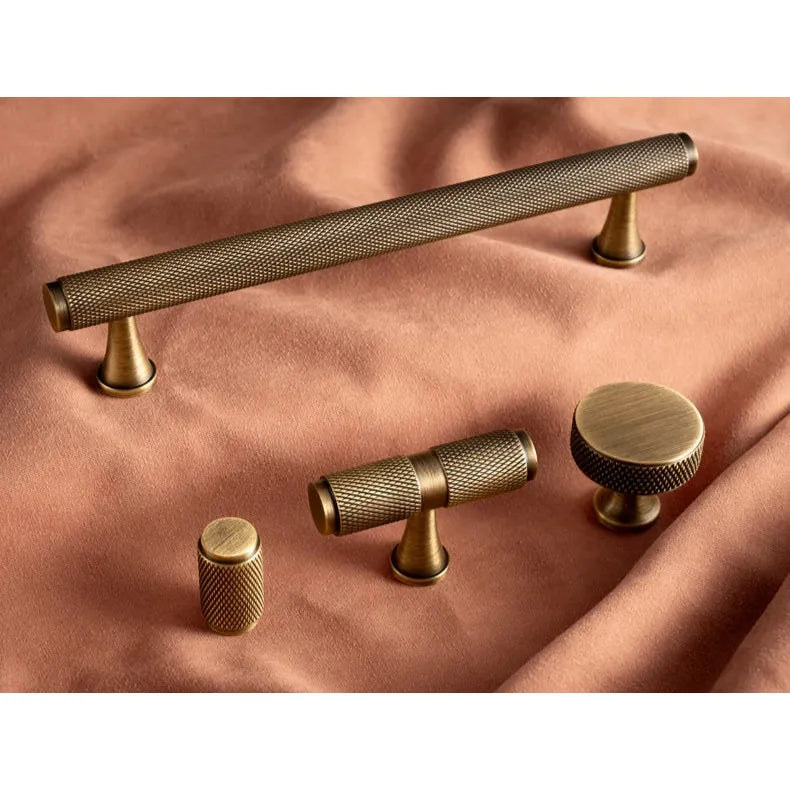 Messing knoppen en grepen van Aurel luxury hardware op roze stof, modern en klassiek design
